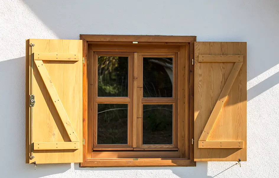 Menuiserie extérieure en Normandie : fenêtre en bois et volets battants posés sur une façade