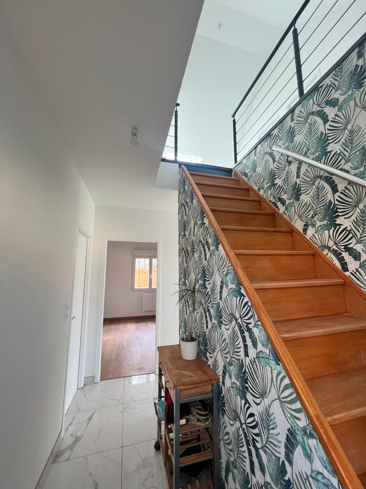 Entrée rénovée : escalier en bois et papier peint tropical, rénovation intérieure en Normandie