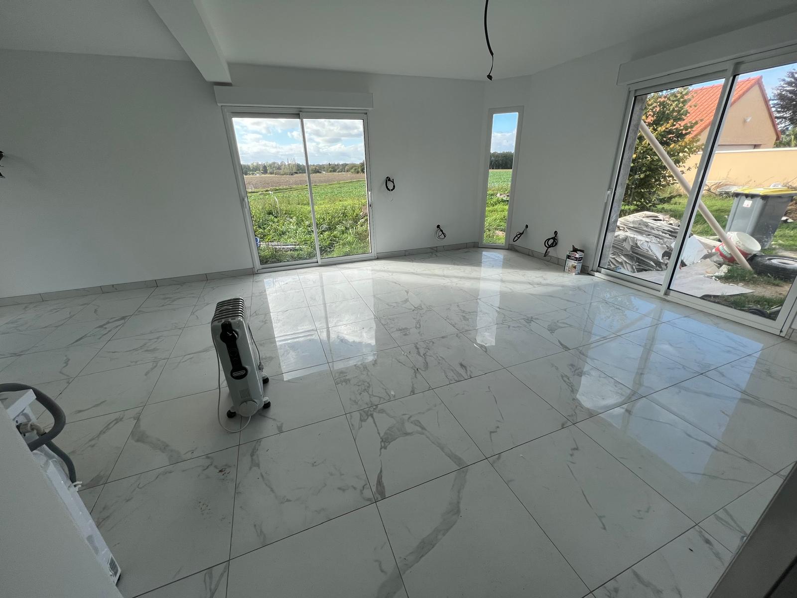 Carrelage grand format effet marbre posé dans un séjour, rénovation intérieure en Normandie